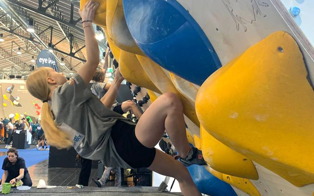 Junge Boulderin klettert bei einem Wettbewerb